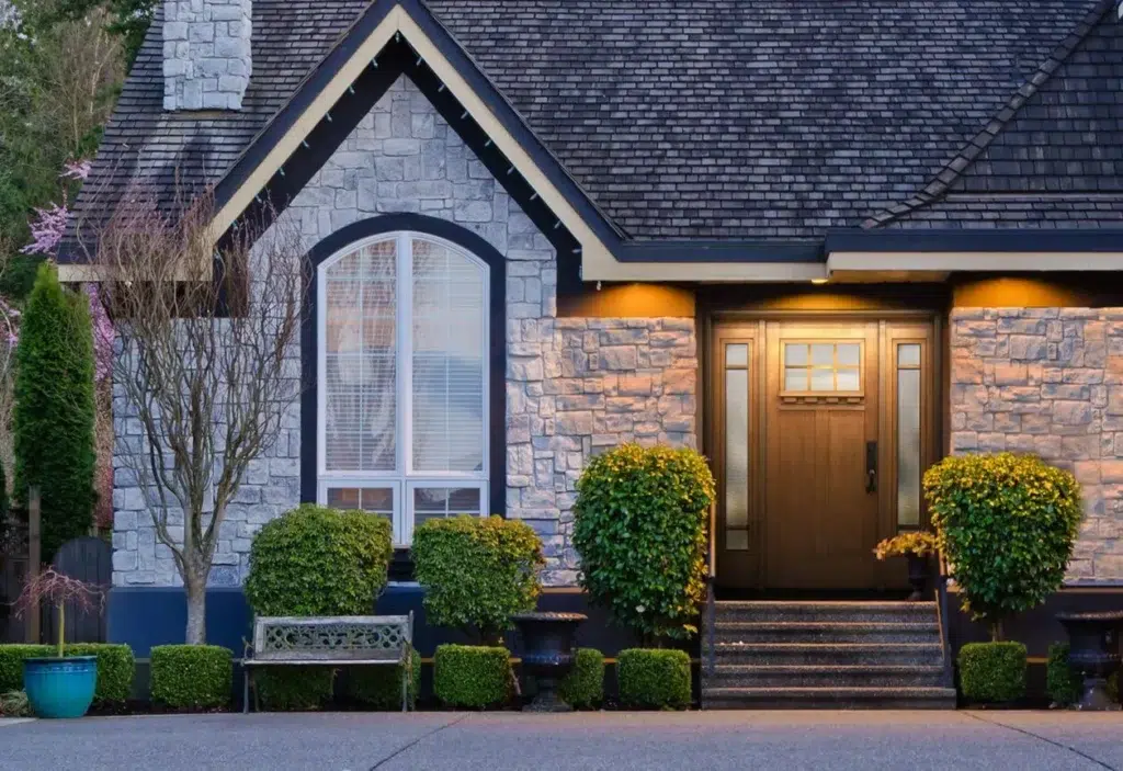 Stone home exterior with arched front entry at dusk
