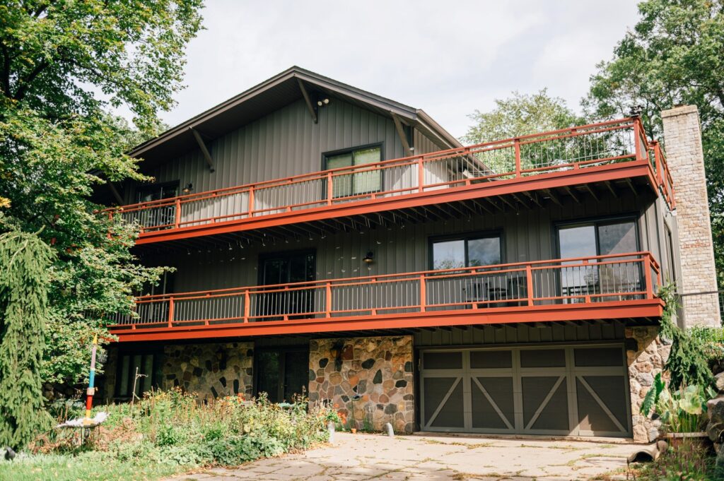 Multi-level home with wood railings and exterior balcony