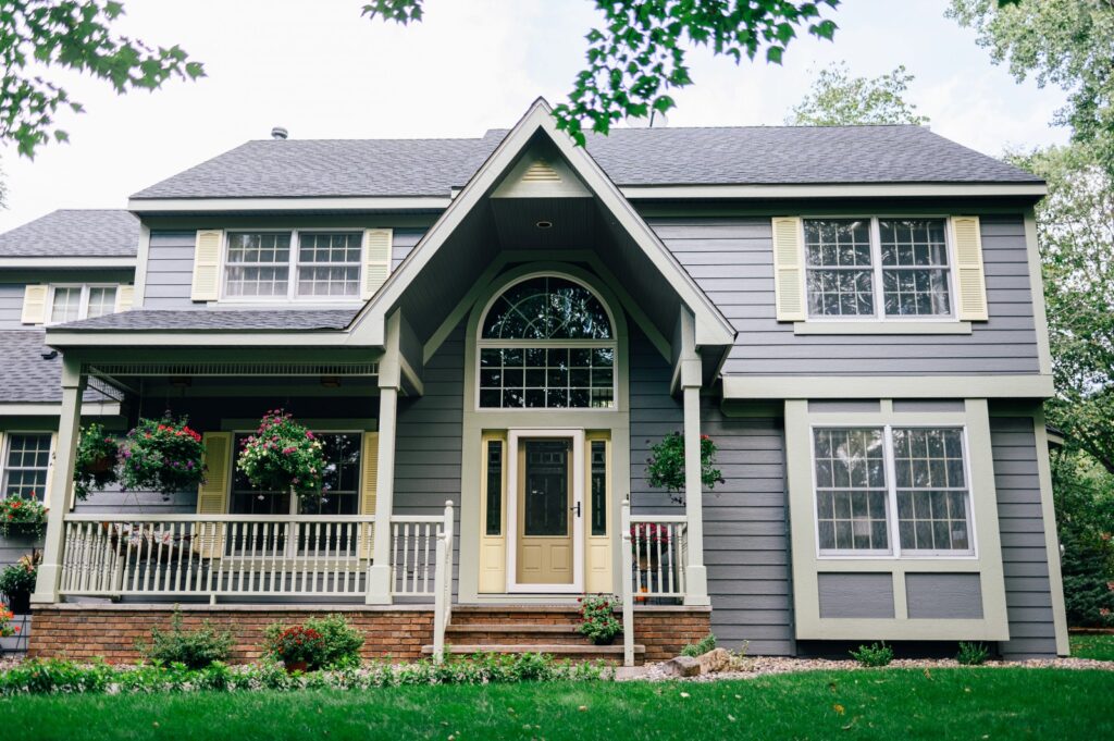 Two-story craftsman home with arched entryway and dark siding