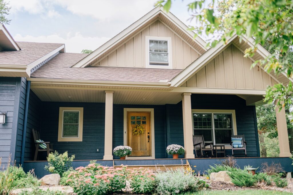 Craftsman-style home with green siding and yellow front door