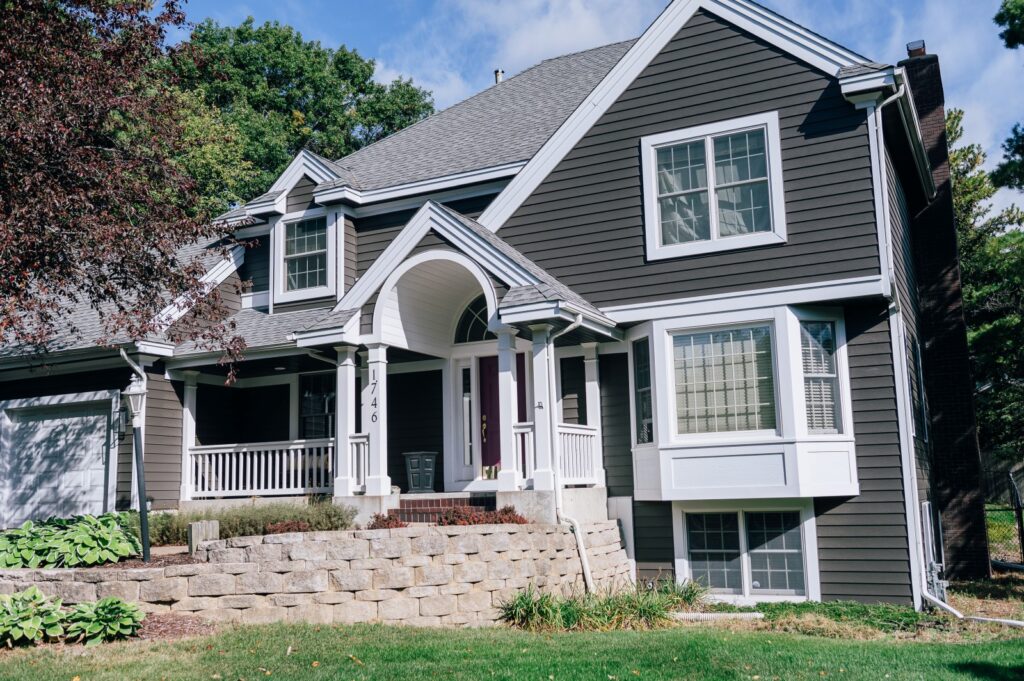 Two-story home with front porch, gray siding, and white trim